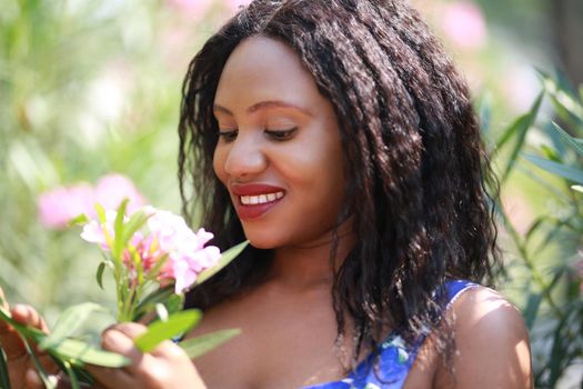 Cheerful young woman standing at outdoor with flower.