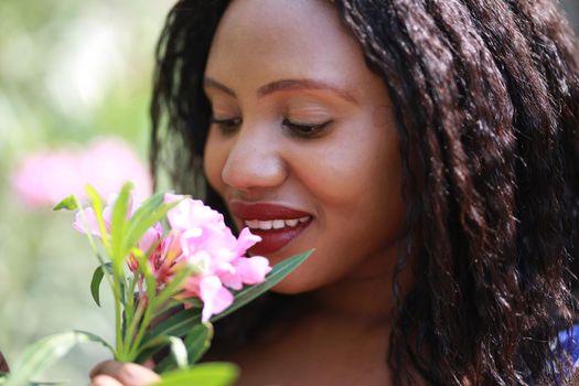 Cheerful young woman standing at outdoor with flower.