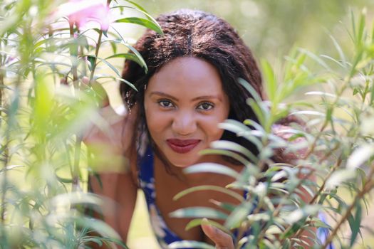 Cheerful young woman standing at outdoor with flower.