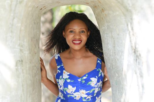 Cheerful young woman standing at outdoor with flower.
