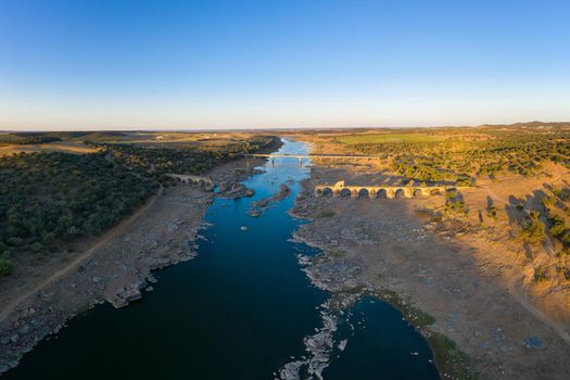 Destroyed abandoned Ajuda bridge drone aerial view, crossing the Guadiana river between Spain and Portugal