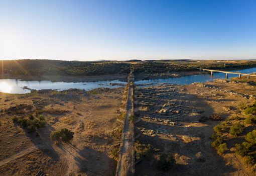 Destroyed abandoned Ajuda bridge drone aerial view, crossing the Guadiana river between Spain and Portugal