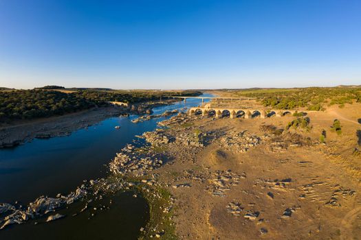 Destroyed abandoned Ajuda bridge drone aerial view, crossing the Guadiana river between Spain and Portugal