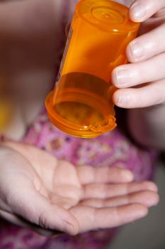 Woman dumping medication from a bottle into her hand