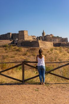 Caucasian woman looking at Juromenha castle on a summer day in Alentejo, Portugal