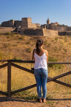 Caucasian woman looking at Juromenha castle on a summer day in Alentejo, Portugal