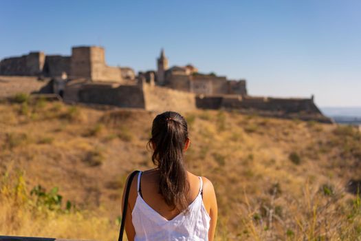 Caucasian woman looking at Juromenha castle on a summer day in Alentejo, Portugal