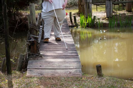 Blind woman standing on a bridge over water