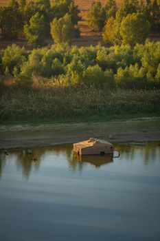 Wooden fishermen house inside water on Guadiana river between Spain and Portugal with beautiful tree landscape at sunrise