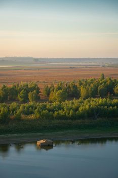 Wooden fishermen house inside water on Guadiana river between Spain and Portugal with beautiful tree landscape at sunrise