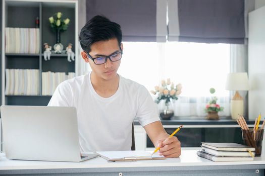 Young man working and learning online at home. Young man video call conference online with his colleagues.