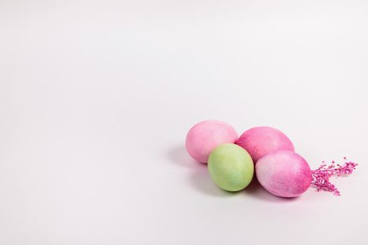 Easter. Multi-colored eggs with twigs, on a white background with a place for text. View from above