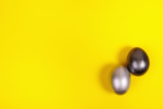 Easter. Multi-colored eggs on a uniform yellow background with place for text. View from above