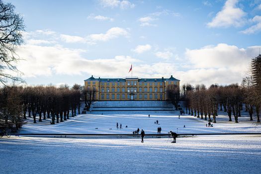 Copenhagen, Denmark - January 06, 2021: People enjoying a snowy winter day in front of the palace in Frederiksberg Gardens