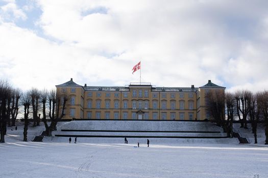 Copenhagen, Denmark - January 06, 2021: People enjoying a snowy winter day in front of the palace in Frederiksberg Gardens