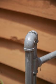 Close up of metal plumbing pipe leading into a home