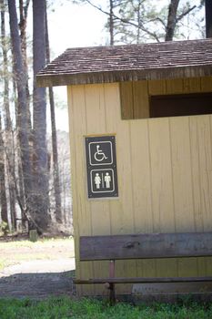 Handicapped accessible yellow outdoor bathroom for men and woman