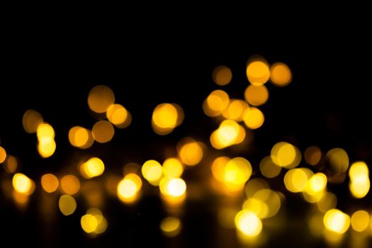 Golden shining bokeh on black background. Decoration or christmas background.Blurred and soft focus.