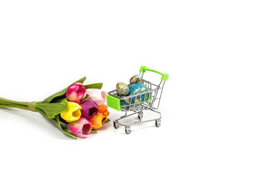 Shopping basket with painted Easter eggs and a bouquet of tulips isolated on a white background