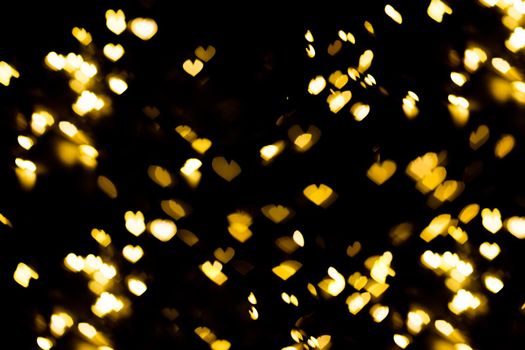 Golden shining bokeh on black background. Decoration for valentine's day or christmas background.Blurred and soft focus.