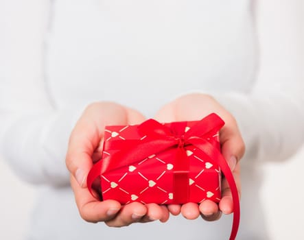 Valentine's Day. Woman beauty hands holding small gift package box present wrapped paper with ribbon isolated on white background, Birthday, New year, Christmas, holiday background concept