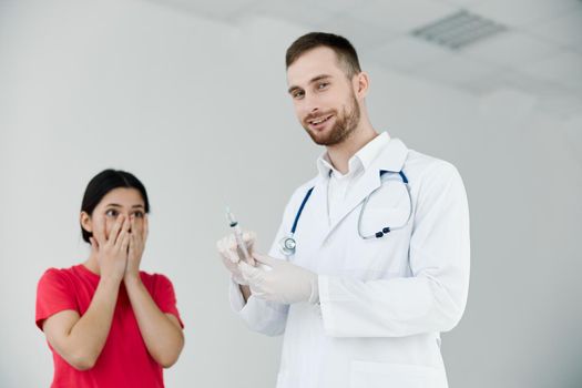 male doctor holding a syringe in his hands the patient is afraid of injections. High quality photo