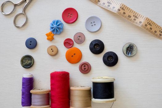 Brightly colored buttons and sewing cotton, flat lay