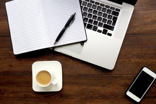 Coffee and notepad with computer, wooden desk