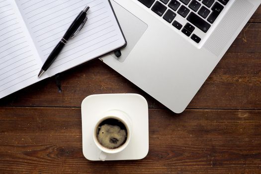 Coffee and notepad with computer, wooden desk