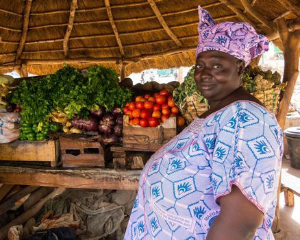 BAMAKO, MALI - CIRCA FEBRUARY 2012: Malian woman selling vegetables on the side of the road.