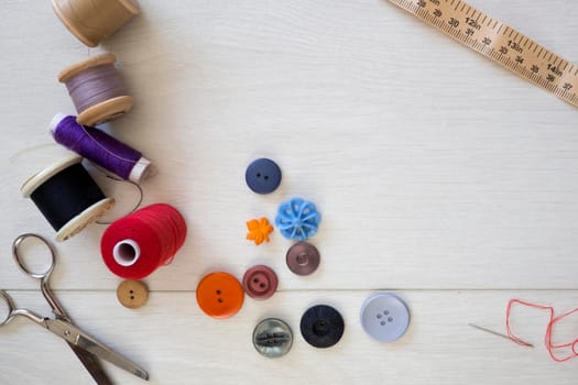 Brightly colored buttons and sewing cotton, flat lay