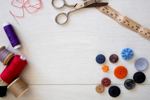Brightly colored buttons and sewing cotton, flat lay