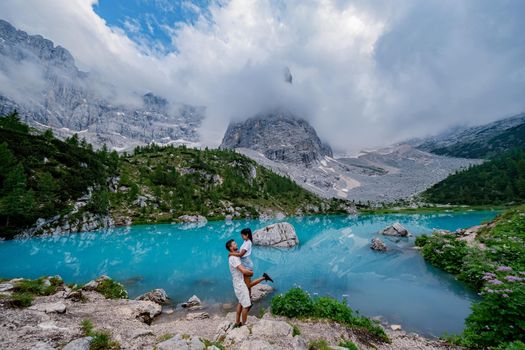 Beautiful Lake Sorapis Lago di Sorapis in Dolomites, popular travel destination in Italy. Blue green lake in Italian Dolomites. Couple hiking in the Dolomites Italy