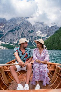 Beautiful lake in the Italian Alps, Lago di Braies in the Italian Dolomites Europe. Braies lake, Italy. The famous lake in the Dolomites, a couple of men and woman mid-age visit Prager wildsee rowing boat