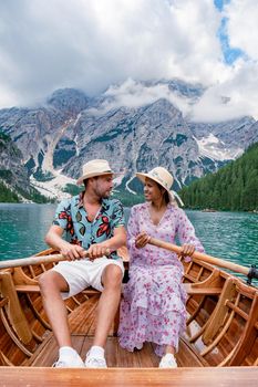Beautiful lake in the Italian Alps, Lago di Braies in the Italian Dolomites Europe. Braies lake, Italy. The famous lake in the Dolomites, a couple of men and woman mid-age visit Prager wildsee rowing boat