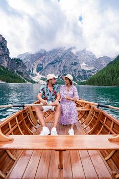 Beautiful lake in the Italian Alps, Lago di Braies in the Italian Dolomites Europe. Braies lake, Italy. The famous lake in the Dolomites, a couple of men and woman mid-age visit Prager wildsee rowing boat