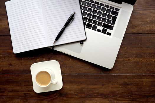 Coffee and notepad with computer, wooden desk