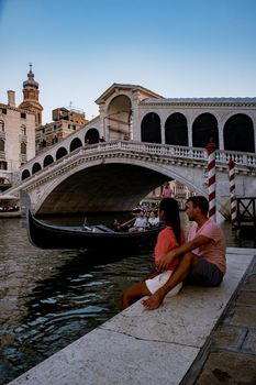 Canals of Venice Italy during summer in Europe,Architecture and landmarks of Venice. Italy Europe, couple men and woman looking at Rialto Bridge Venice Italy June 2020