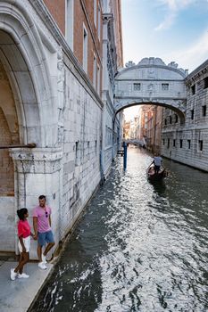 Canals of Venice Italy during summer in Europe,Architecture and landmarks of Venice. Italy Europe, couple man and woman mid age visiting bridge of sights in Venice