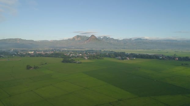 Aerial view: villages, farmer fields, rice terraces in mountain valley. Philippines, Luzon. Rice terraces in a mountain province. Tropical landscape in Asia.