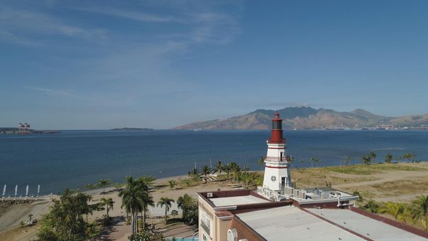 Coastline with beach and lighthouse, mountains. Aerial view: Coast sea with hotels, resorts, Subic Bay, Philippines, Luzon