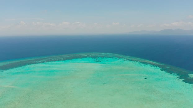 Tropical coral atoll with turquoise water against the sky with clouds top view. Summer and travel vacation concept. Balabac, Palawan, Philippines