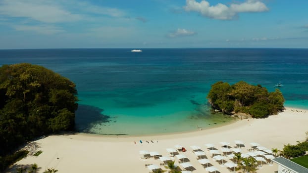 Tropical beach with sun beds near the lagoon with turquoise water Boracay, Philippines, aerial view. Seascape with beach on tropical island. Summer and travel vacation concept.