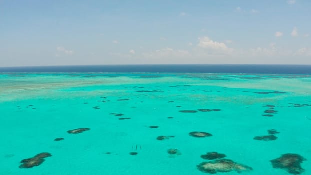 Tropical coral atoll with turquoise water against the sky with clouds top view. Summer and travel vacation concept. Balabac, Palawan, Philippines