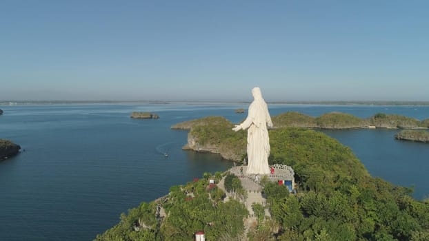 Statue of Jesus Christ on Pilgrimage island in Hundred Islands National Park, Pangasinan, Philippines. Aerial view of group of small islands with beaches and lagoons, famous tourist attraction, Alaminos.