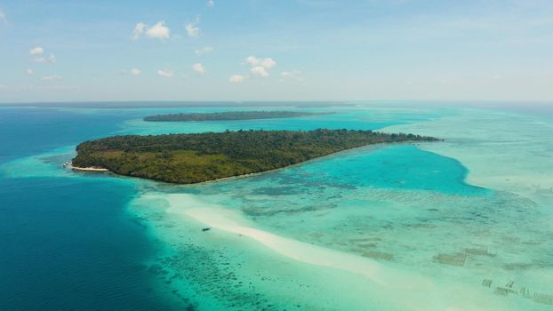 Island with a sandy beach and azure water surrounded by a coral reef and an atoll, aerial view. Mansalangan sandbar, Balabac, Palawan, Philippines. Summer and travel vacation concept