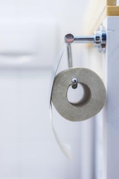 Close up of toilet paper roll on chrome hanger