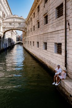 Canals of Venice Italy during summer in Europe,Architecture and landmarks of Venice. Italy Europe, couple man and woman mid age visiting bridge of sights in Venice