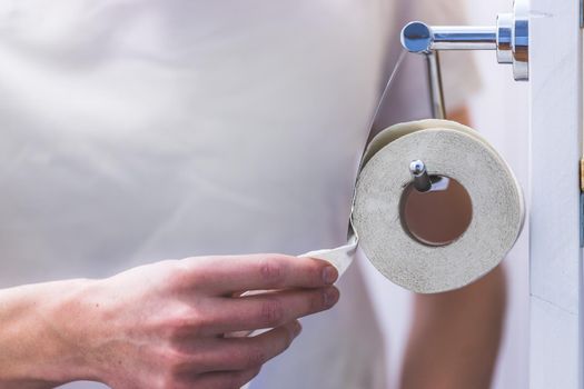 Hand of a male person using toilet paper