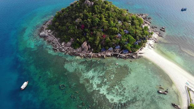 Calm colorful azure turquoise sea near tiny tropical volcanic island Koh Tao, unique small paradise Nang Yuan. Drone view of peaceful water near stony shore and green jungle on sunny day in Thailand